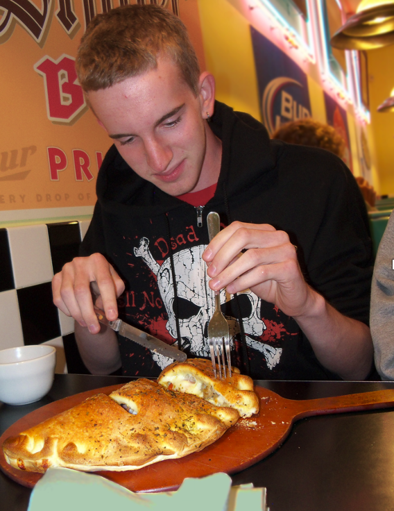 photo of Adam about to start eating the Calzone.